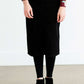 Woman wearing a black below the knee denim midi skirt.
