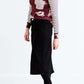 Woman wearing a black below the knee denim midi skirt.