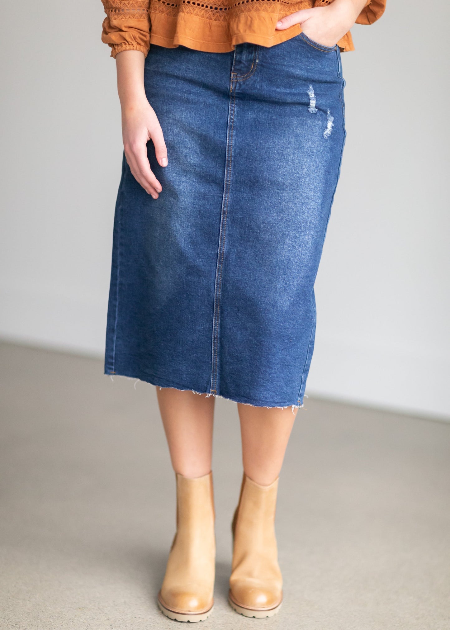 An Inherit Exclusive, the Remi Raw Hem Dark Denim Midi Skirt is cut with a modest and classic straight fit. This dark denim skirt has a raw bottom hem and will be a go-to time and time again for any occasion! The slight distressing at the hip adds fun style to your closet without any thought at being dressy or casual as it is definitely both! This skirt has awesome stretch for total comfort and no back slit while still allowing for unconstrained walking.