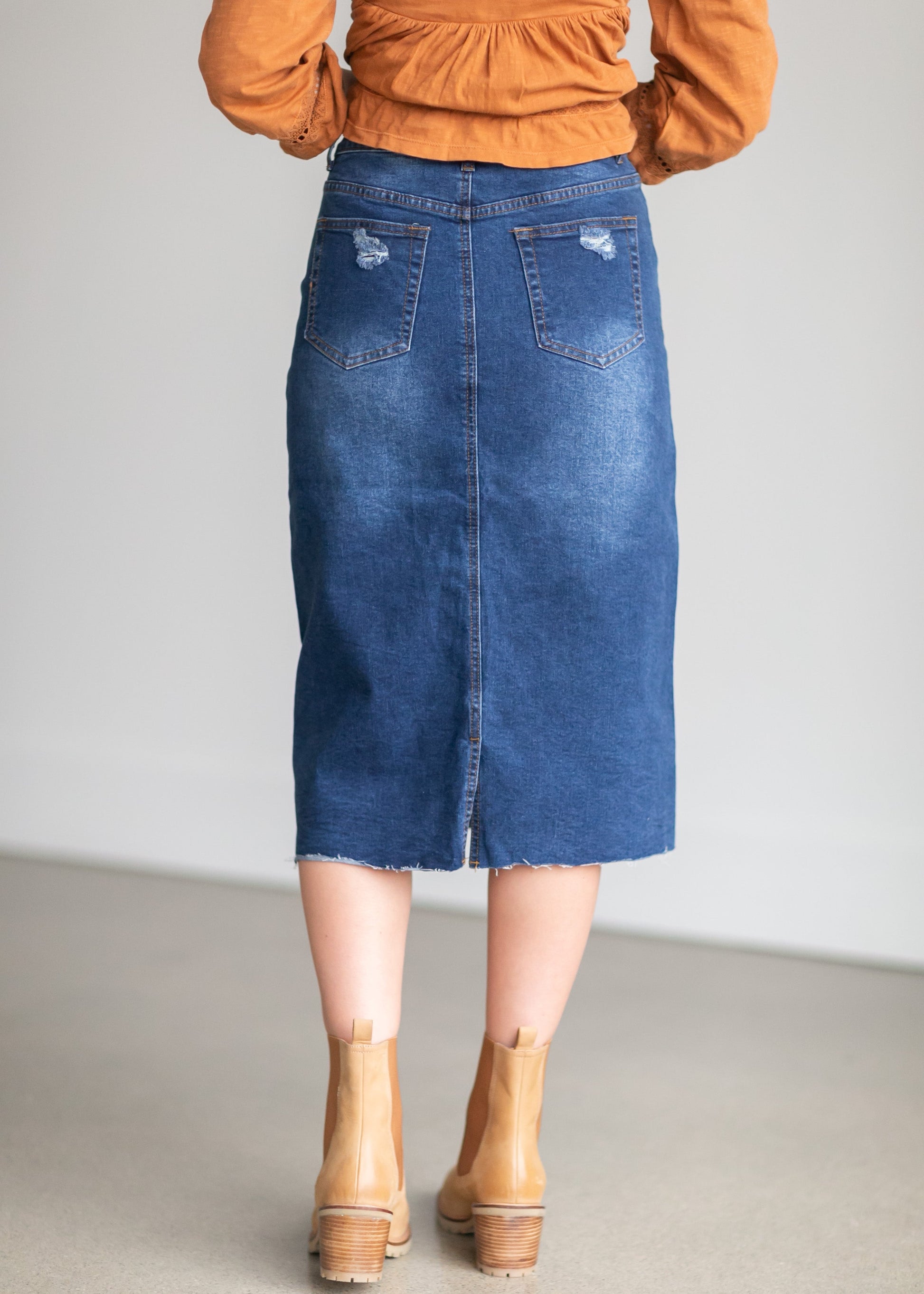An Inherit Exclusive, the Remi Raw Hem Dark Denim Midi Skirt is cut with a modest and classic straight fit. This dark denim skirt has a raw bottom hem and will be a go-to time and time again for any occasion! The slight distressing at the hip adds fun style to your closet without any thought at being dressy or casual as it is definitely both! This skirt has awesome stretch for total comfort and no back slit while still allowing for unconstrained walking.