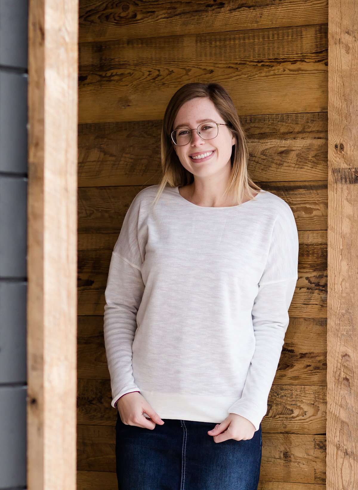 woman wearing a reversible knit top in purple and white 