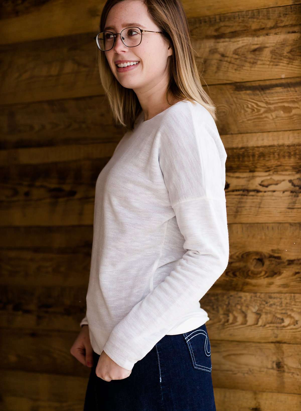 woman wearing a reversible knit top in purple and white 