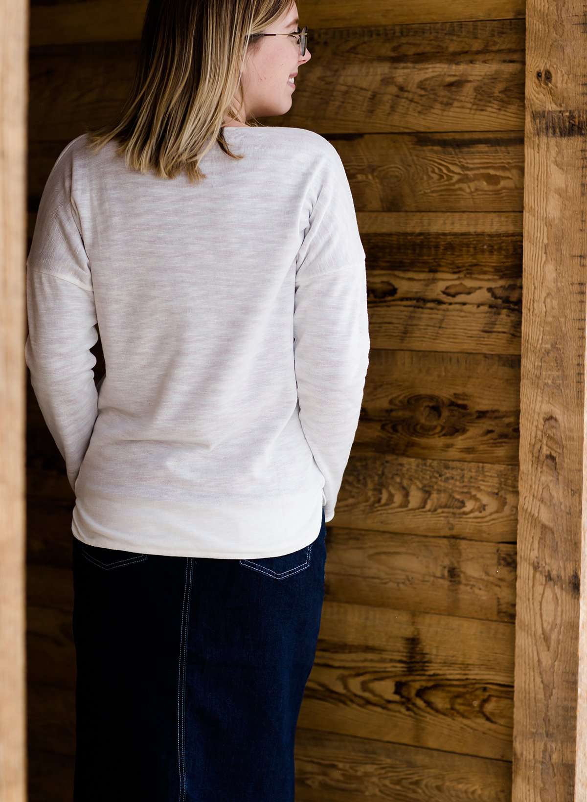 woman wearing a reversible knit top in purple and white 