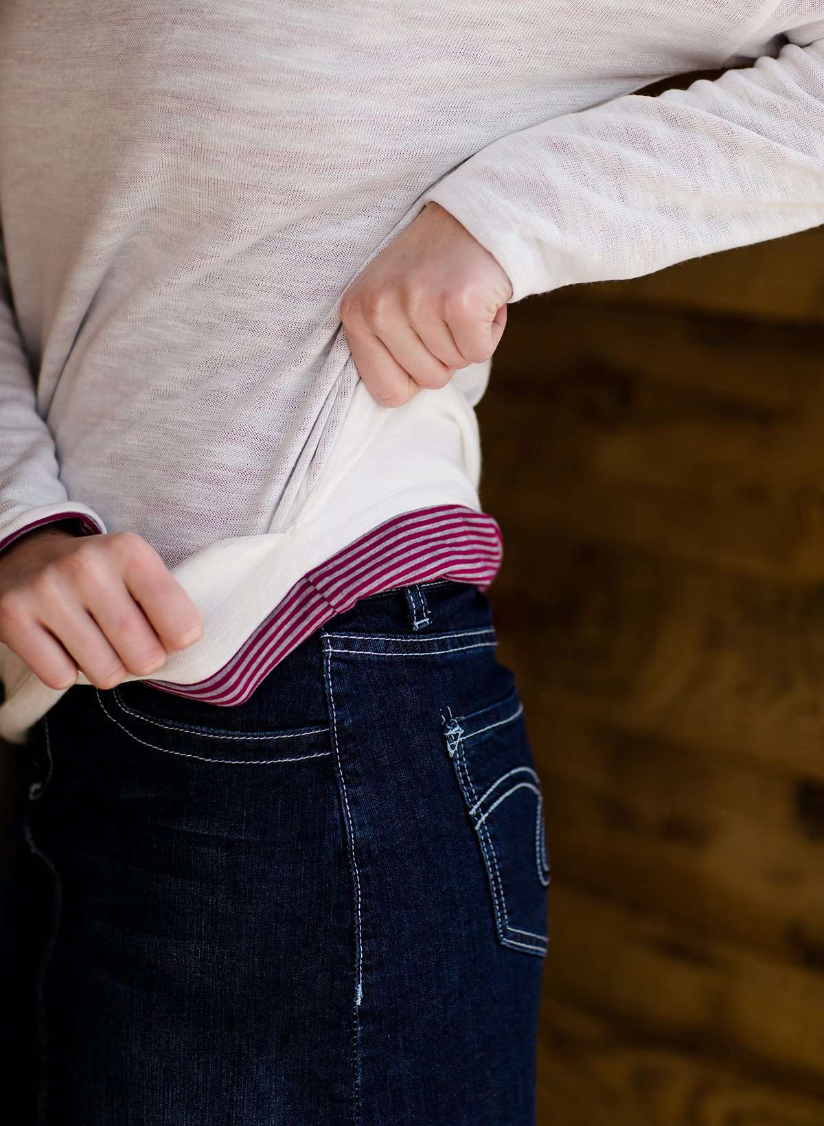 woman wearing a reversible knit top in purple and white 