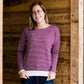 woman wearing a reversible knit top in purple and white 