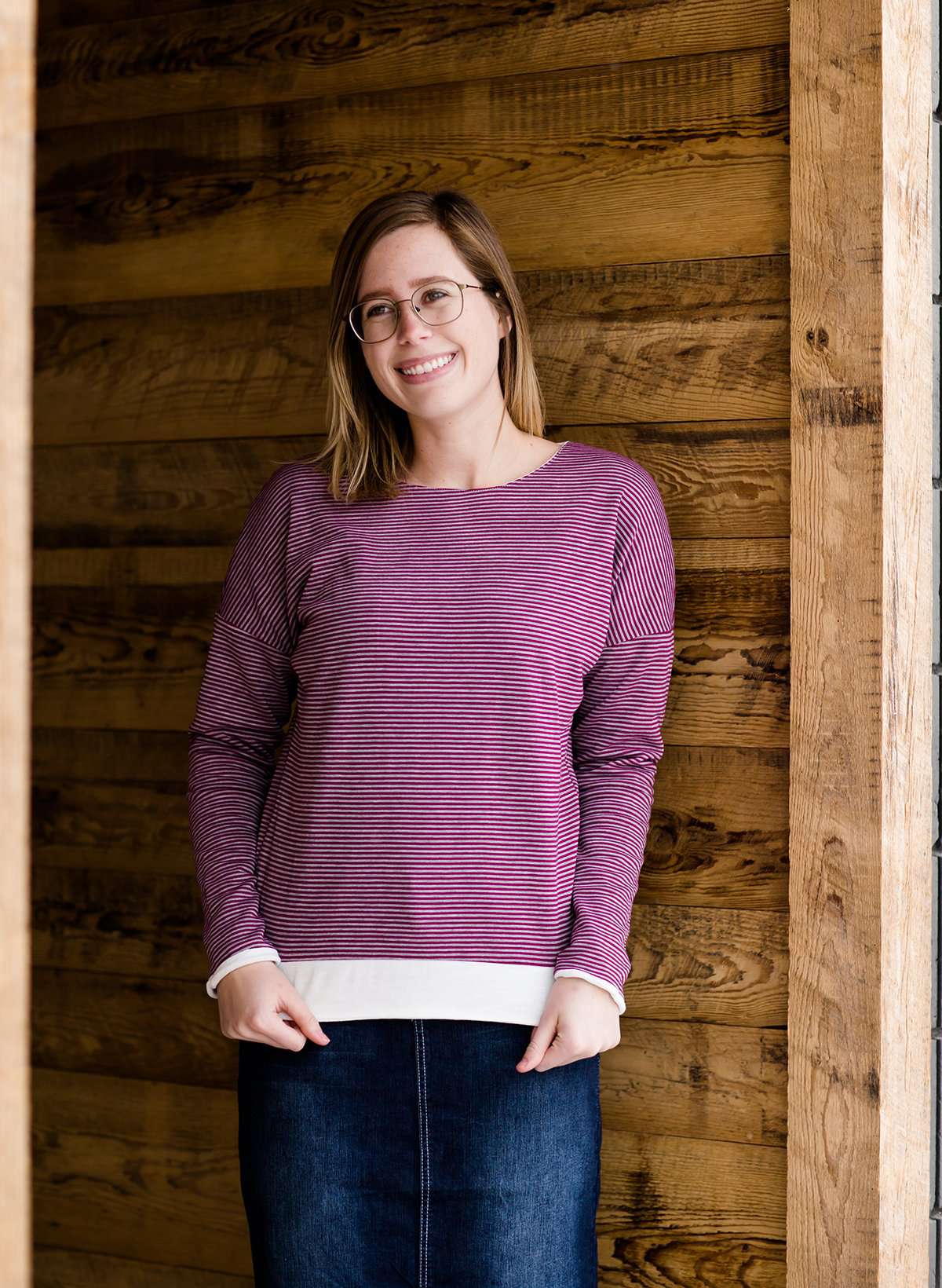 woman wearing a reversible knit top in purple and white 