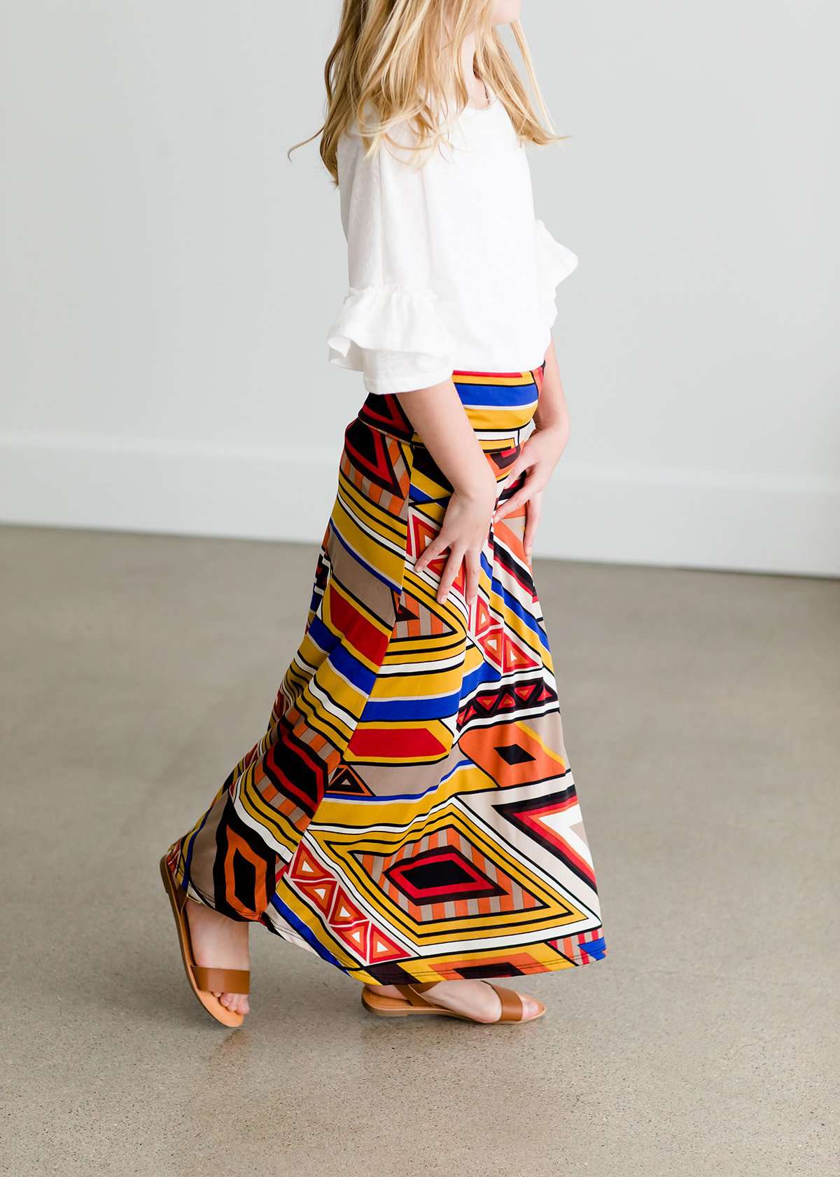Girl wearing a modest maxi dress that is multi color and stretchy
