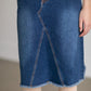 The Riley Frayed Hem Denim Midi Skirt is an Inherit Design that is full of lovely details! It is tailored in a slight a-line fit and super comfortable for anyone wanting that timeless look! This skirt is a darker wash with contrast stitching with a v-stitch in the front and back. You will love the raw bottom hem and the faux leather patch on the back!