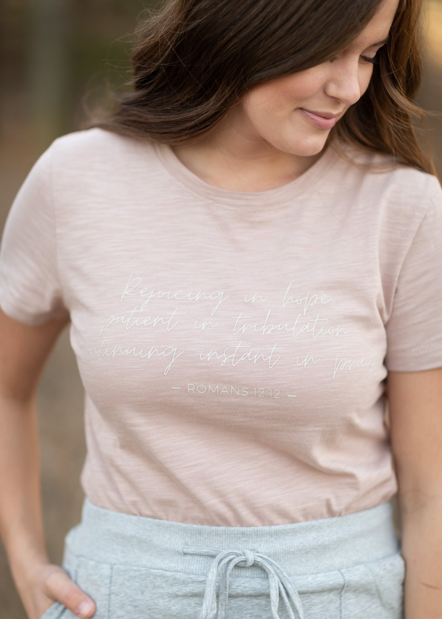 This custom Romans Graphic Tee is an Inherit Design tailored in a feminine fit. The sleeve length is a true short sleeve that will go with anything. It is a pink with a slight heathered look that isn't see-through! The white writing on the front says "Rejoicing in hope, patient in tribulation; continuing instant in prayer." - Romans 12:12 for a daily reminder in your walk with the Lord!
