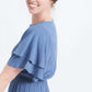 woman wearing a dusty blue empire waist dress with double ruffle sleeves that is lined and falls below the knee