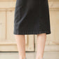 Woman wearing a modest black denim skirt that falls below the knee