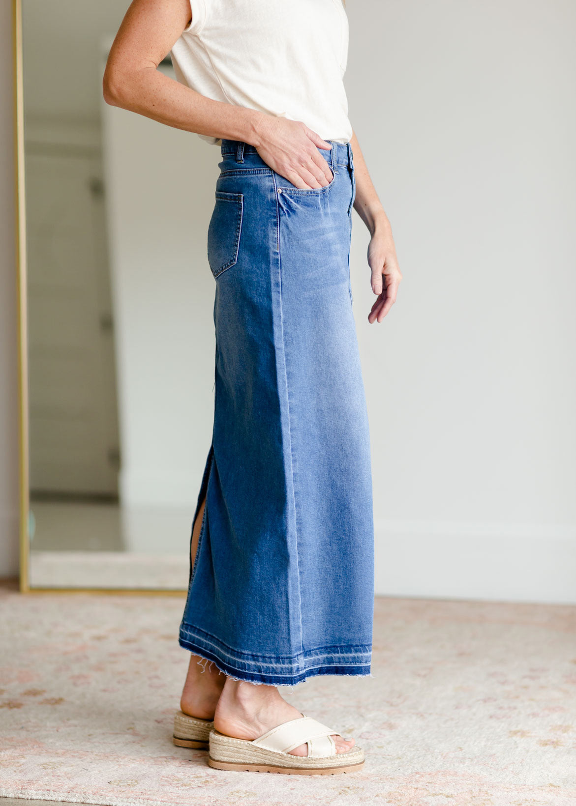 The Stacy skirt is long denim with a raw hem and slight monkey washing in a medium wash. This is an inherit designed long denim mdest skirt.