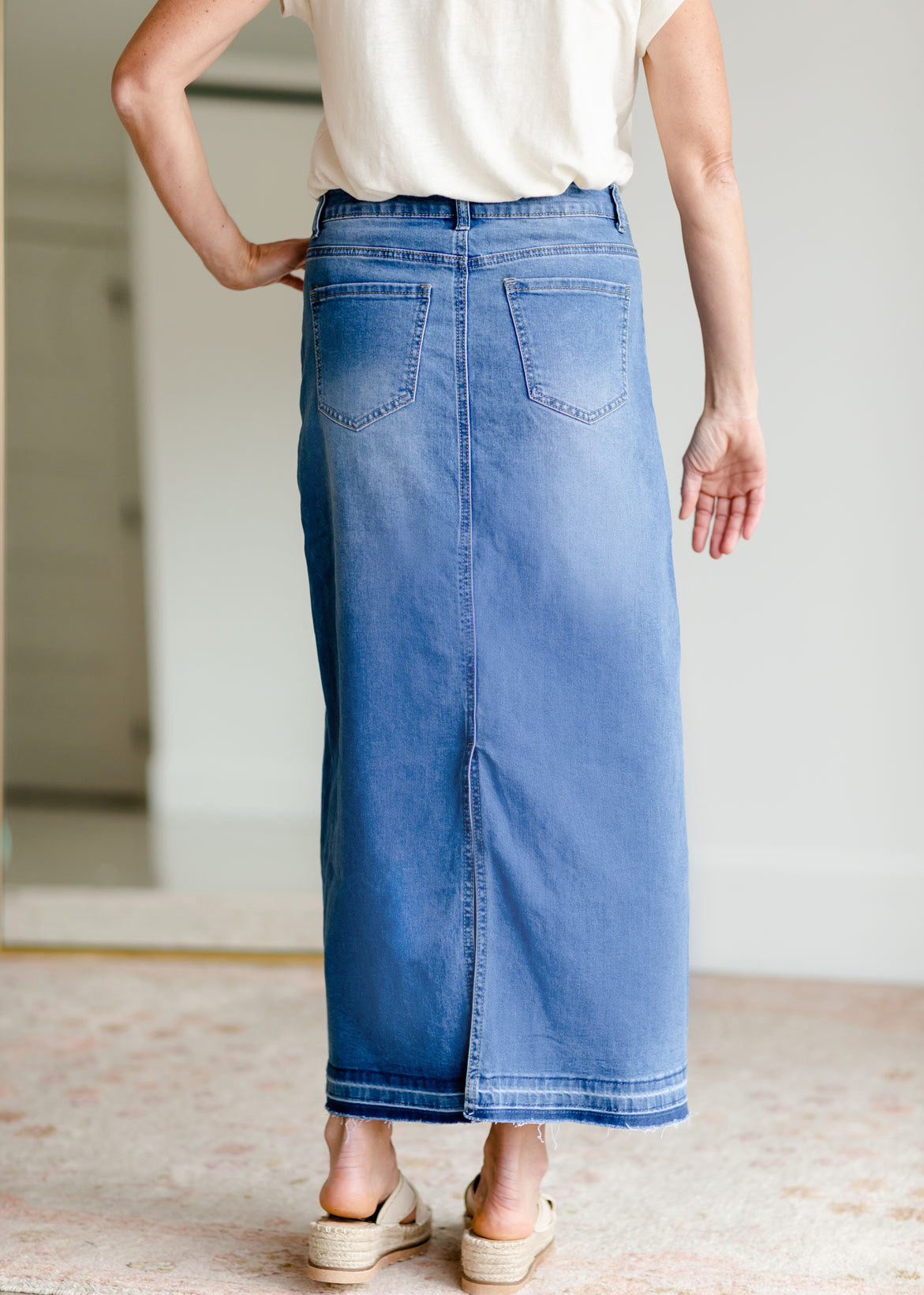 The Stacy skirt is long denim with a raw hem and slight monkey washing in a medium wash. This is an inherit designed long denim mdest skirt.